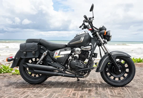 دراجة نارية من فئة Benelli Motobi 200 Evo باللونين الأسود والكروم مع مصباح أمامي دائري ومقعد منخفض وعوادم طويلة وأكياس جانبية