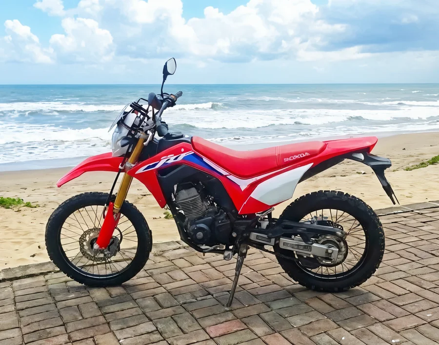 Red Honda CRF150L lightweight dual-sport motorcycle with tall suspension, spoked wheels and trail-oriented tyres