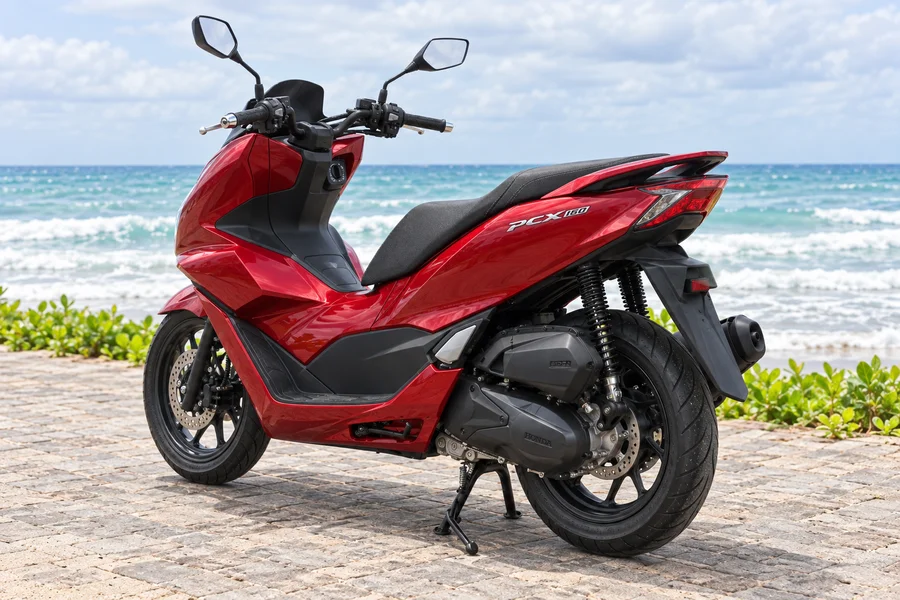 Rød Honda PCX160, forfra-venstre, ved havet